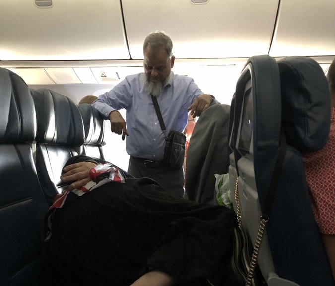 Man stands in plane for wife to sleep